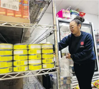  ?? PHOTOS: ERROL MCGIHON ?? Community and Family Services Supervisor Diana Javiers fills a food bag in the cramped food storage room at The Salvation Army Ottawa Booth Centre.