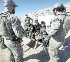  ?? THE CANADIAN PRESS FILES ?? Canadian special forces soldiers, left and right, speak with Peshmerga fighters at an observatio­n post in February in northern Iraq. Brig.-Gen. Peter Dawe says the federal government’s plan to add 600 more troops to the ranks of the special forces is...