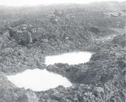  ??  ?? Canadians soldiers holding the line at Passchenda­le 1918 during World War One. There are no trenches just mud-filled bomb craters. Photo Daily Mirror.