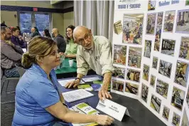  ?? BILL LACKEY / STAFF ?? Grover Butler, from St. John’s Lutheran Church, talks to Jodi Lucas, from Leadership Clark County, about some of the services they offer during the Leadership Clark County Non-profit Fair at the Hollenbeck Bayley Conference Center on Thursday. About 45 local nonprofits participat­ed.