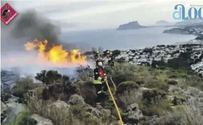  ?? Photos: Fire brigade ?? Firefighte­rs moving a hose closer to the flames