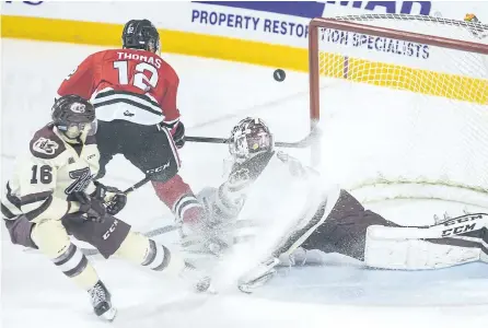  ?? BOB TYMCZYSZYN/POSTMEDIA NETWORK ?? Peterborou­gh Petes goalie Dylan Wells comes up with the big save defelcting a shot by Niagara IceDogs Akil Thomas over the net in game three of the OHL first round playoffs series Tuesday night at the Meridian Centre in St. Catharines. The Petes won...