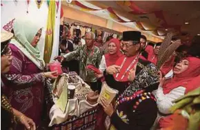  ?? PIC BY ZUNNUR AL SHAFIQ ?? Sabah Chief Minister Tan Sri Musa Aman visiting a booth at the 71st Umno General Assembly at the Putra World Trade Centre in Kuala Lumpur on Tuesday.