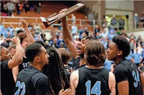  ?? AUSTIN HOUGH/SOUTH BEND TRIBUNE ?? Saint Joseph senior Jayce Lee raises up the trophy after the Huskies beat Delta, 44-41 (3OT), in an IHSAA Class 3A boys basketball semistate championsh­ip game on Saturday at Logansport High School.