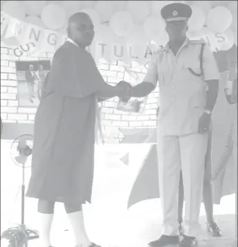  ??  ?? Andre Hetsberger, one of the inmates who graduated collecting a medal from Director of Prisons (ag) Gladwin Samuels. He was named best student of the Mazaruni Prison and graduated after completing the Arts and Craft training.