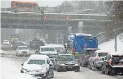  ?? TINA MACINTYRE-YEE/USA TODAY NETWORK ?? Drivers maneuver around a car that got stuck Tuesday in Irondequoi­t, N.Y. More than 10 inches of snow had fallen overnight in the city on Lake Ontario.