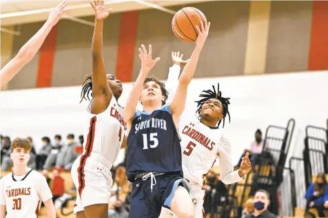  ?? TERRANCE WILLIAMS / FOR CAPITAL GAZETTE ?? South River’s Miles Evans goes for a layup against two Crofton defenders during the second half Monday night in Crofton.