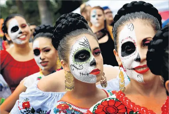  ?? Mark Ralston AFP/Getty Images ?? PEOPLE in costume at the Dia de los Muertos event at the Hollywood Forever Cemetery in 2016. There are 19 Day of the Dead festivitie­s across Greater L.A. this year.
