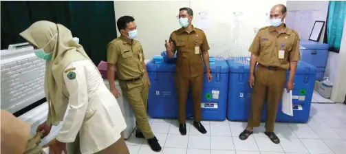  ?? GUSLAN GUMILANG/JAWA POS ?? SIAPKAN TEMPAT: Para staf Dinkes Sidoarjo ketika menyiapkan cool box untuk menyimpan vaksin gelombang kedua di ruang khusus kantor dinkes.