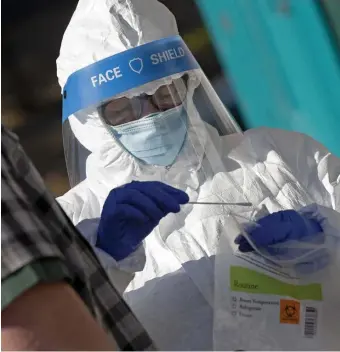  ?? MATT STONE / HErALD STAFF ?? PREVENTING SPREAD: Melissa Leaston, director of nursing at Whittier Street Health Center, swabs a patient at a COVID-19 testing site in Nubian Square on Thursday in Roxbury.