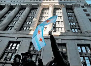  ?? STACEY WESCOTT/CHICAGO TRIBUNE ?? Linda Bhavilai waves a Chicago flag as she marches with striking teachers outside City Hall on Oct. 23, 2019.