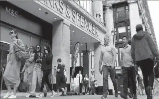  ?? LONDON
-REUTERS ?? People walk outside Marks&Spencer shop amid outbreak of the coronaviru­s disease in London, Britain.