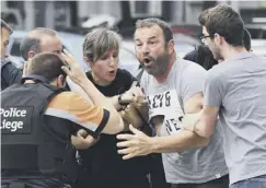  ??  ?? 0 Police hold back a distraught bystander after Liege attack