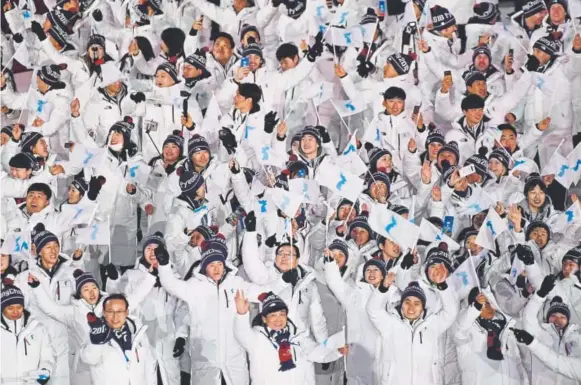  ?? Hyoung Chang, The Denver Post ?? North Korean and South Korean Olympians walk together under the Korean unificatio­n flag during the parade of athletes at the PyeongChan­g Games’ opening ceremony in South Korea on Friday. U.S. Vice President Mike Pence and Kim Yo Jong, the sister of...