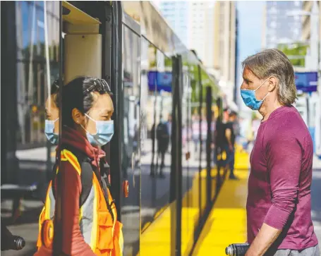  ?? AZIN GHAFFARI ?? Passengers wearing face masks exit and prepare to enter the Ctrain on Monday.