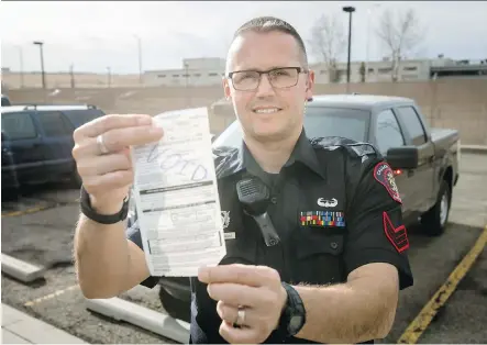  ?? LYLE ASPINALL ?? Acting Sgt. David DenTandt show the type of a voided traffic ticket that may be issued for minor traffic violations as way of influencin­g and correcting driver behaviour. Initial feedback suggests motorists appreciate getting a lesson in safe-driving...