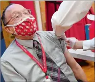  ?? SEAN D. ELLIOT/THE DAY ?? Leo Butler, director of diversity at NFA, is all smiles Friday as pharmacist Greg McKenna administer­s a dose of the Moderna COVID-19 vaccine as medical staff from NFA and Nutmeg Pharmacy inoculate staff and faculty during a vaccinatio­n clinic in Norton Gymnasium.