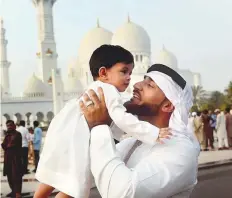  ?? Abdul Rahman/Gulf News ?? Zaki Mohammad Ahmad from Saudi Arabia exchanges Eid greetings with his 10-month-old son Aydin at the Shaikh Zayed Grand Mosque in Abu Dhabi early yesterday.