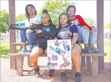  ?? Rachel Aston Las Vegas Review-journal @rookie__rae ?? Jaylon Tiffith’s niece Wynesha Lewis, second from right, and his sisters, from left, Monika Carter, Taylor Tiffith and Eliza Tiffith hold a poster and wear shirts bearing pictures of him. The 29-year-old North Las Vegas man was fatally shot last month.