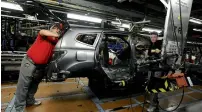  ?? — Reuters ?? Nissan technician­s work on a Qashqai car on the production line at the company’s plant in Sunderland, Britain.