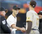  ?? Bay Area News Group via AP photo ?? The Giants’ Tyler Rogers (left) shakes hands with brother Taylor Rogers of the Padres as they exchange lineups before Monday’s game.