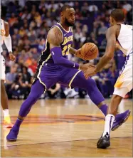  ?? AP PHOTO BY MATT YORK ?? Los Angeles Lakers forward Lebron James (23) drives past Phoenix Suns forward Trevor Ariza during the first half of an NBA basketball game, Wednesday, Oct. 24, in Phoenix.