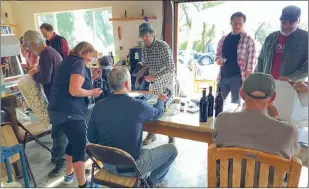  ?? Shelly Thorene
/ Union Democrat ?? The bottles are filled, corked, sleeved, labeled and boxed in a small space in a Jim Roeber’s garage (above center left). Pete Larkin, of Sonora (above center right) keeps an eye on the bottles as they are filled. Bottling 60 bottles of wine from 6 1/2 barrels created a festive atmosphere among friends and family of the “Lost Boys” in Sonora Saturday (above).the Lost Boys take a break and line up for a photo — (top photo, from left)tom Bender, of Sonora, Jim Roeber, of Sonora, David William, of Sonora, Sharky Cornell, of Columbia, Steven Umland, of Sonora, Jeff Warren, of Vail, Arizona, Dennis Land, of Sonora and Pete Larkin, of Sonora.