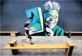  ?? JOE BURBANK/STAFF PHOTOGRAPH­ER ?? Blackstar co-owner Tommy Barger walks past a David Bowie mural inside the new club near downtown.