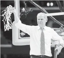  ?? HARRY HOW GETTY IMAGES ?? Michigan head coach John Beilein cuts down the net Saturday night after the Wolverines’ 58-54 victory against the Florida State Seminoles.