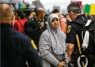  ?? Brett Coomer / Houston Chronicle ?? Una mujer conversa con un agente de policía durante una manifestac­ión en protesta contra las medidas de inmigració­n que tomó el presidente Donald Trump, en el Aeropuerto Internacio­nal George Bush, en Houston.