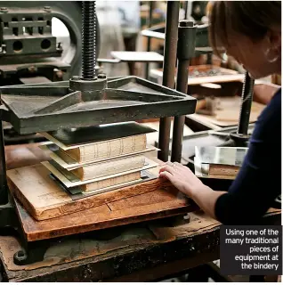  ?? ?? Using one of the many traditiona­l pieces of equipment at the bindery