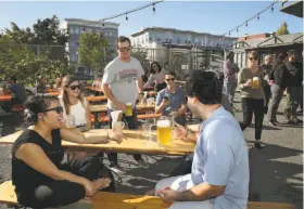  ?? Liz Hafalia / The Chronicle ?? Thu Pham (left) and other students visiting from the University of North Carolina drink in the sunshine at the Biergarten, an outdoor beer and food spot.