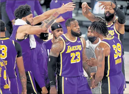  ?? AP ?? Los Angeles Lakers' Lebron James, center, celebrates with teammates during Saturday’s victory over the Denver Nuggets.