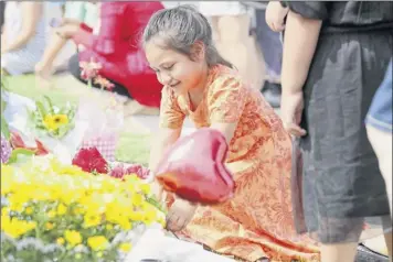  ?? Michael Bradley /Getty Images ?? Residents pay their respects by placing flowers for the victims of the mosques attacks in Christchur­ch at the Masjid Umar mosque in Auckland on Sunday.The death toll from horrifying massacres at two mosques in New Zealand rose to 50, police said Sunday, as Christchur­ch residents flocked to memorial sites and churches across the city to mourn the victims.