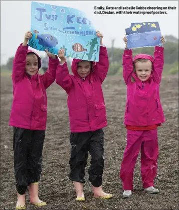  ??  ?? Emily, Cate and Isabelle Cobbe cheering on their dad, Declan, with their waterproof posters.