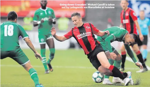  ??  ?? Going down: Crusaders’ Michael Carvill is takenout by Ludogorets ace Marcelinho at Seaview