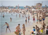  ?? (Miriam Alster/Flash90) ?? ISRAELIS ENJOY the beach in Tel Aviv on Saturday, as temperatur­es rise to 40C (104F) in some parts of the country.