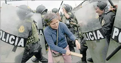  ?? Foto Ap ?? ▲ Partidario­s de Pedro Castillo chocan con policías que rodean la comisaría a la que fue llevado el destituido presidente de Perú el día de ayer.