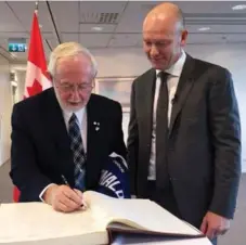  ?? YVONNE COOPER/THE CANADIAN PRESS ?? Scientist Arthur McDonald signs the guest book at the Canadian Embassy in Stockholm beside his hero, former Leafs captain Mats Sundin.