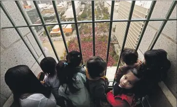  ?? Genaro Molina Los Angeles Times ?? CHILDREN with the Joy Picus Child Developmen­t Center take in a bird’s-eye view of the thousands of educators with United Teachers Los Angeles at a rally on Friday, the fifth day of the walkout, in Grand Park.