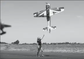  ?? NEWS-SENTINEL FILE PHOTOGRAPH ?? Samantha Katilus reaches up to a hovering plane at a show hosted by the Tokay Radio Control Modelers.