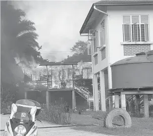  ??  ?? MUSNAH: Rumah guru yang terbakar terletak berhadapan bangunan sebuah rumah guru dua unit jenis konkrit (kanan).
