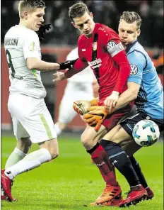  ?? DPA-BILD: GAMBARINI ?? Kampf um den Ball: Leverkusen­s (von rechts) Bernd Leno und Lars Bender bedrängen Aron Johannsson.