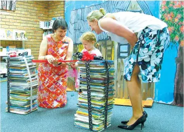  ??  ?? Baw Baw Principal Librarian Kathie Olden (left) and West Gippsland Regional Library Corporatio­n chief executive Leanne Williams (right) assist Madeleine Williams (aged three) to officially launch the 1000 Books Before School program with a ribbon...