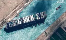  ?? Maxar Technologi­es / AFP via Getty Images ?? A satellite image shows the Ever Given and tugboats. The ship’s crash created a massive traffic jam that held up $9 billion a day in global trade and strained supply chains already burdened by the coronaviru­s pandemic.