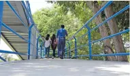  ??  ?? Estudiante­s utilizando el puente peatonal de la Uninorte.