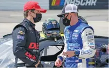  ?? AP PHOTO/STEVE HELBER ?? Cousins Harrison Burton, left, and Jeb Burton talk prior to the start of the rain delayed NASCAR Xfinity Series race at Martinsvil­le Speedway.