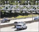  ?? Associated Press file photo ?? Cars pass under toll sensor gantries hanging over the Massachuse­tts Turnpike.