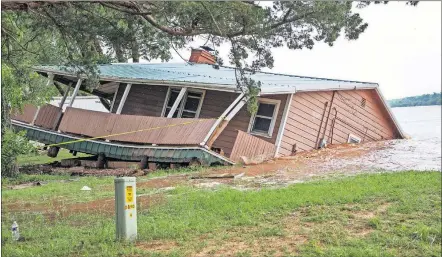  ?? LANDSBERGE­R PHOTOS/THE OKLAHOMAN] [CHRIS ?? Floodwater­s from the Cimarron River wash away a home in the Twin Lakes community, near Cimarron City, on Wednesday.