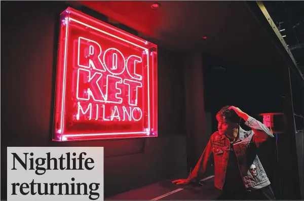  ?? ?? Italian DJ Richey V, real name Francesco Orcese, looks at a neon sign Sept. 25 inside Rocket Club in Milan. (AP/Alberto Pezzali)